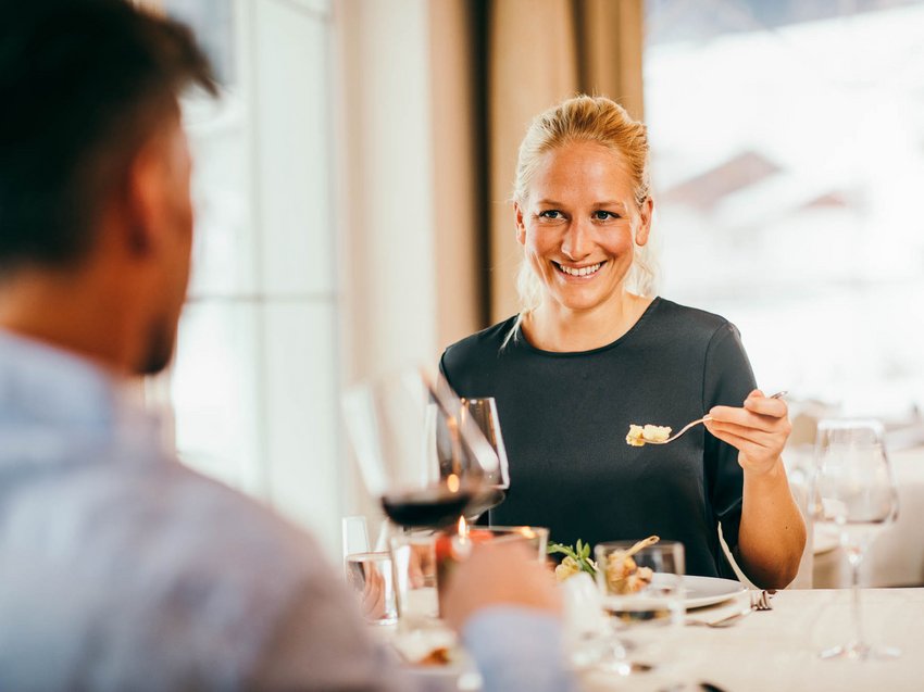 How to make your holiday in Stubaital unforgettably amazing Woman smiling while having dinner with a man in a restaurant