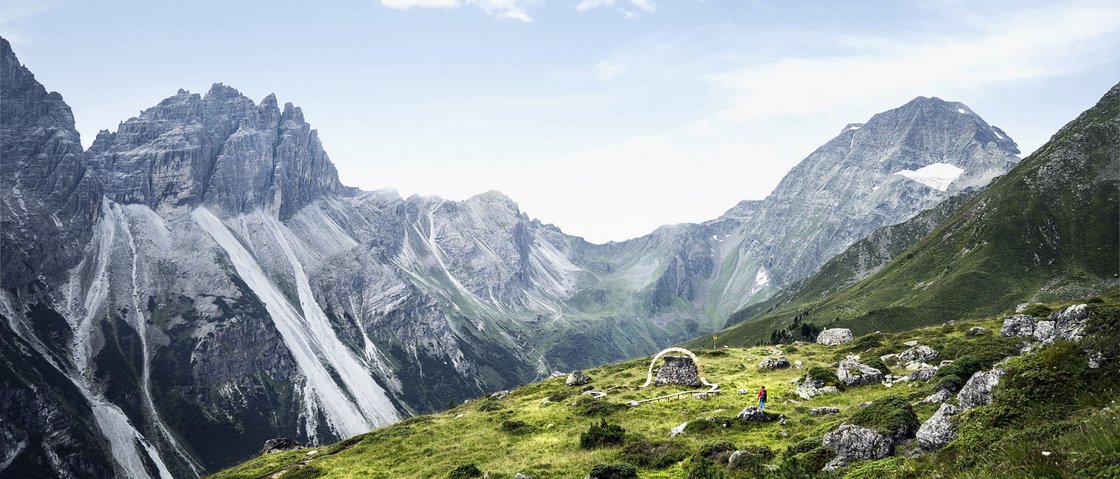 Mountain love at our hiking hotel in Stubaital Green mountain slopes and rocky peaks with a small ruin under a blue sky