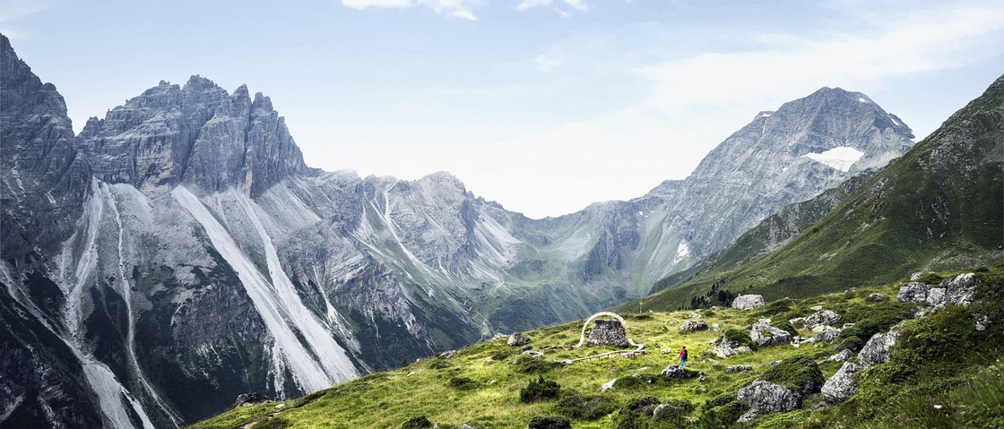 Mountain love at our hiking hotel in Stubaital Green mountain slopes and rocky peaks with a small ruin under a blue sky