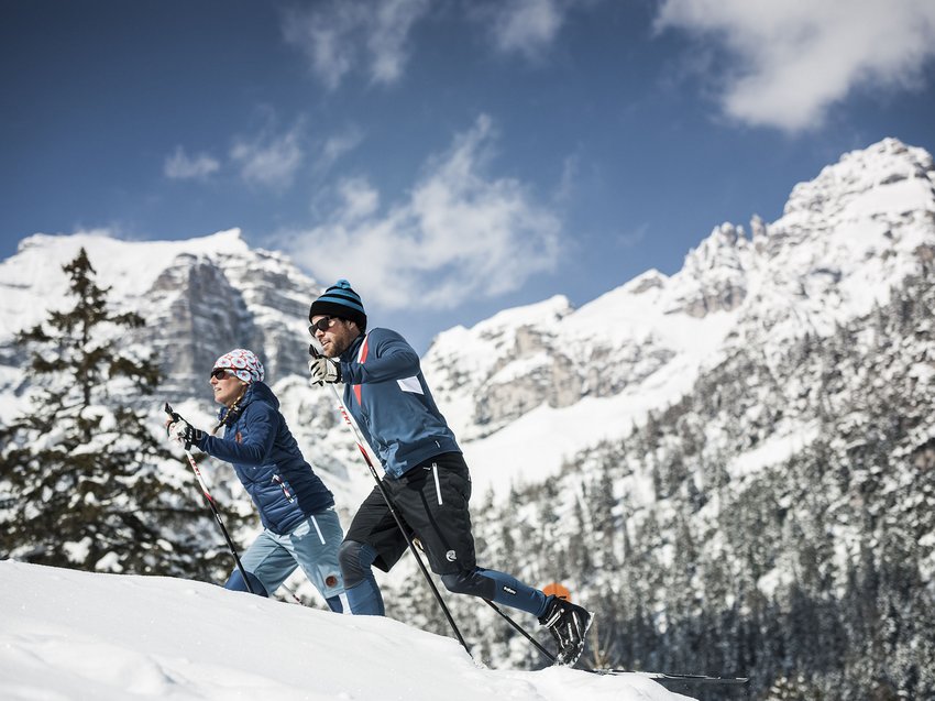 Spannendes rund ums Aktivhotel im Stubaital Zwei Skilangläufer im Schnee mit verschneiten Bergen im Hintergrund