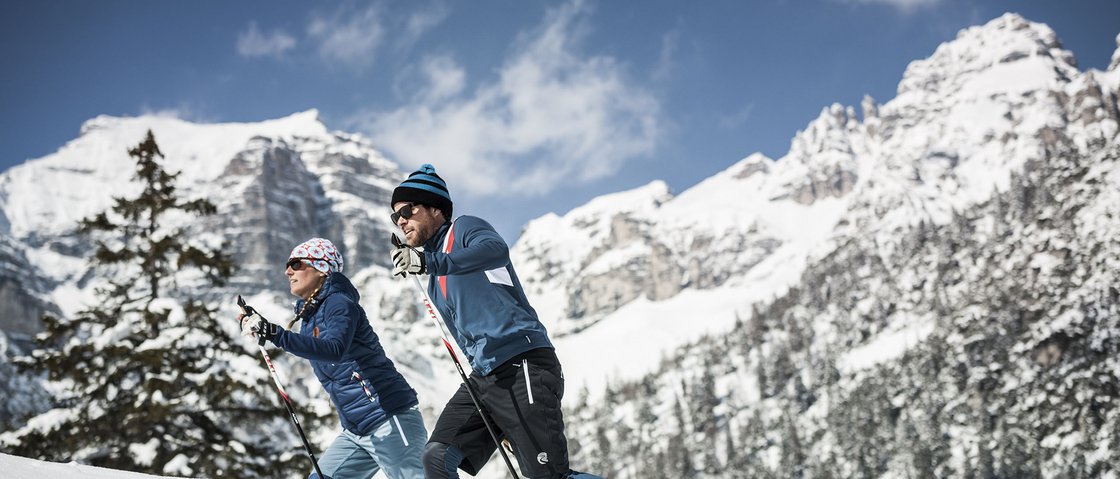 Gaudi im Winterurlaub im Stubaital Zwei Skilangläufer im Schnee mit verschneiten Bergen im Hintergrund