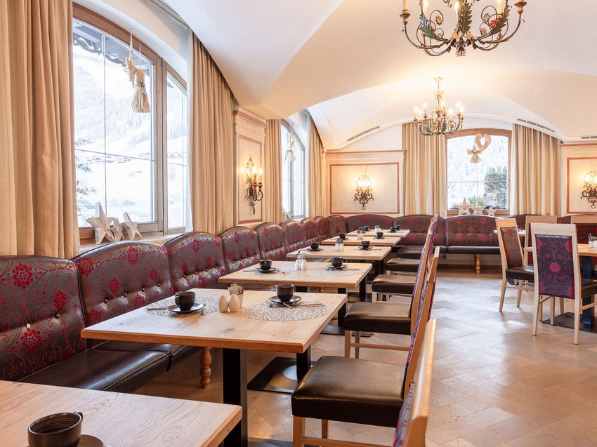 The secret to an indulgent holiday Elegant restaurant with wooden tables, red banquettes, and large windows