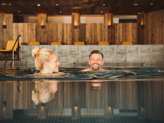 Your wellness hotel in Neustift im Stubaital awaits Couple relaxing together in an indoor pool with wood-panelled walls