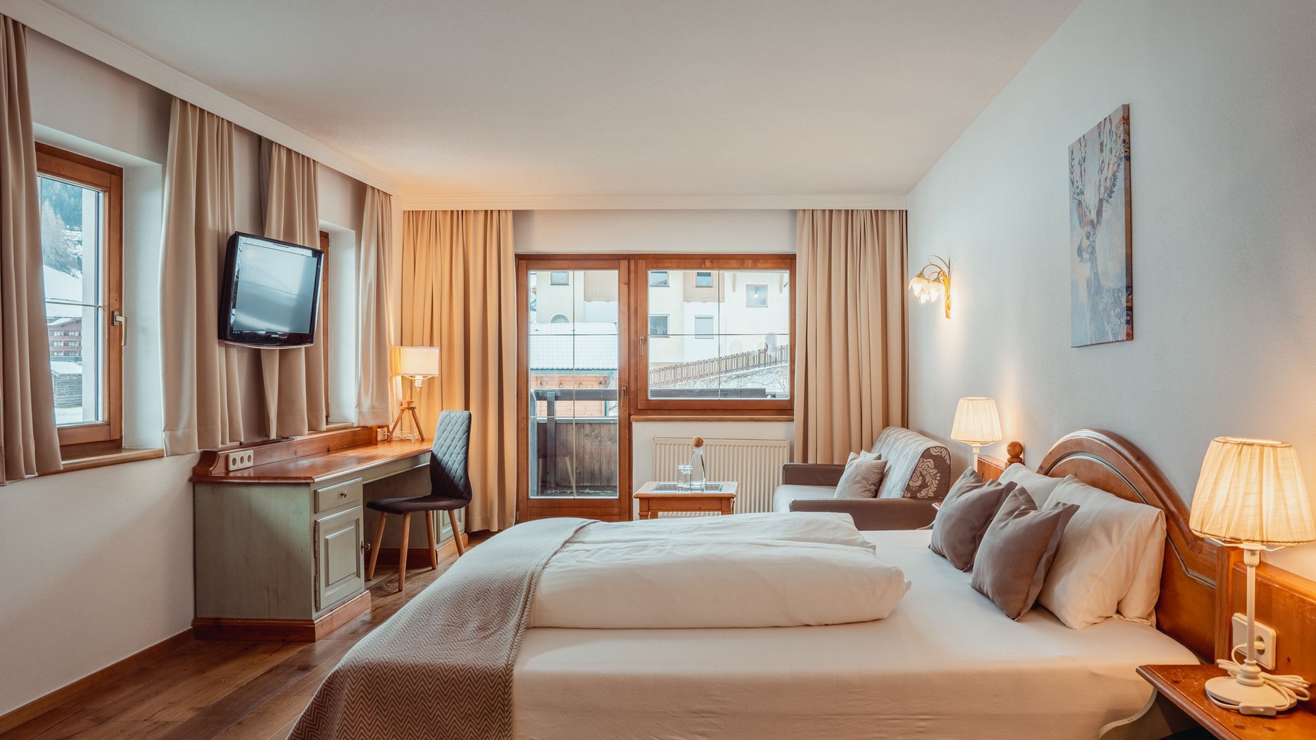 Welcome to our hotel in Neustift im Stubaital! Cozy hotel room with double bed, desk, chair, and sofa near windows