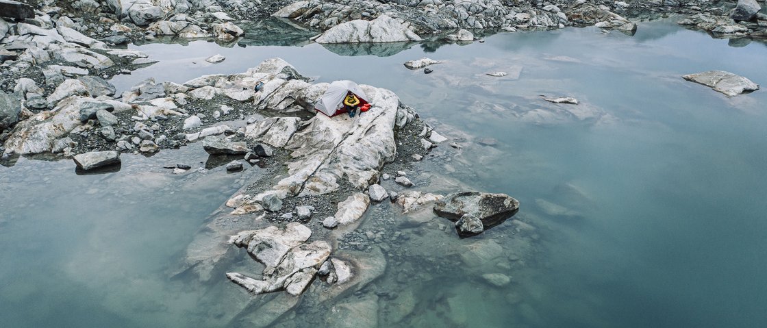 Mountain love at our hiking hotel in Stubaital Tent on rocky shore beside clear blue mountain lake
