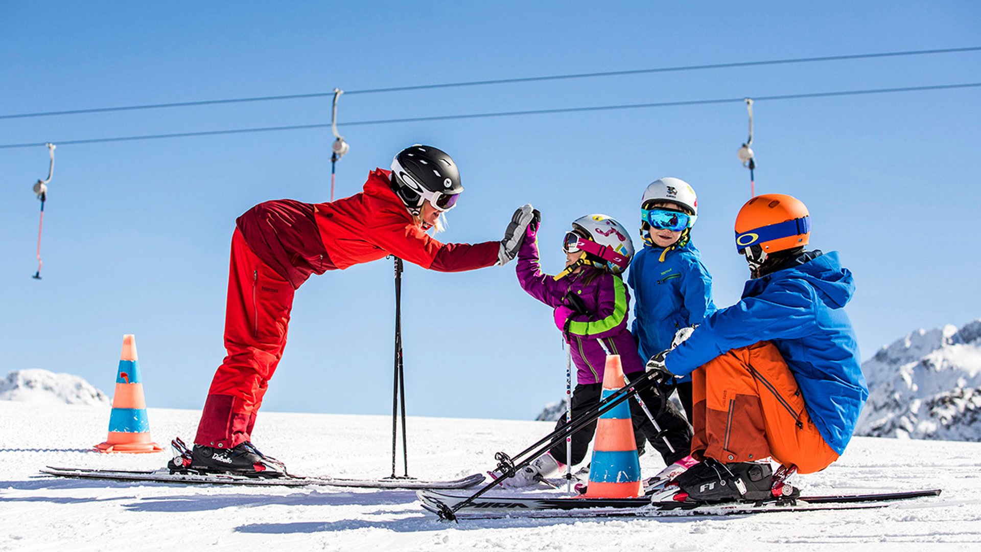 Ski instructor giving high five to children on snowy slope