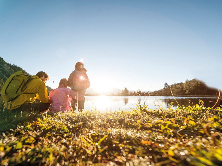 Mountain love at our hiking hotel in Stubaital Three hikers sitting by a lake watching mountains at sunset