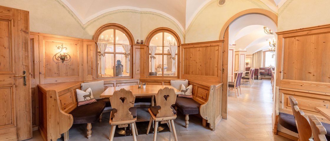 Welcome to our hotel in Neustift im Stubaital! Cozy corner bench with wooden tables and chairs in a traditional dining room