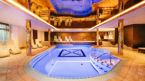 Enquire about your B&B mountain holiday here Modern indoor pool with blue tiles and golden ceiling reflection