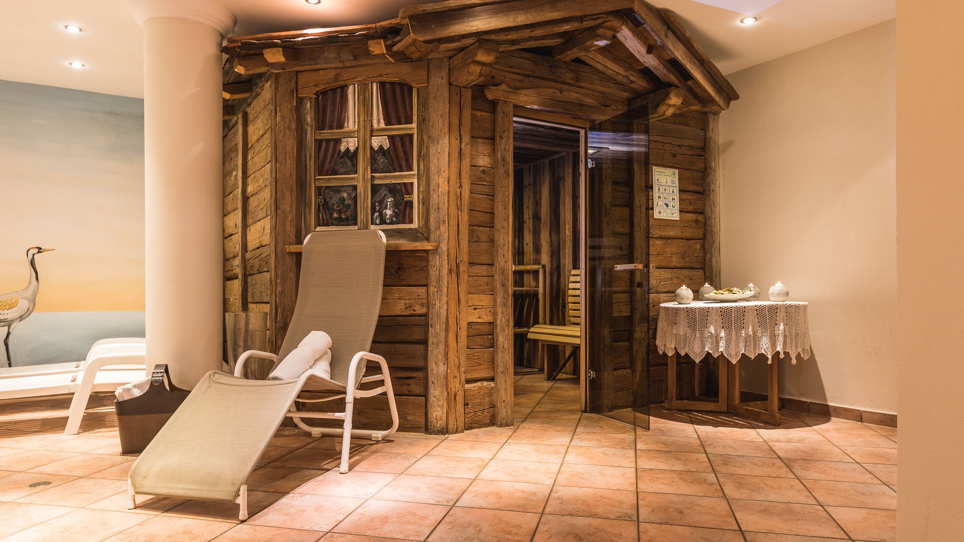 Willkommen im Hotel in Neustift im Stubaital! Entspannungsbereich mit Holzsauna, Liegestuhl und Beistelltisch innen