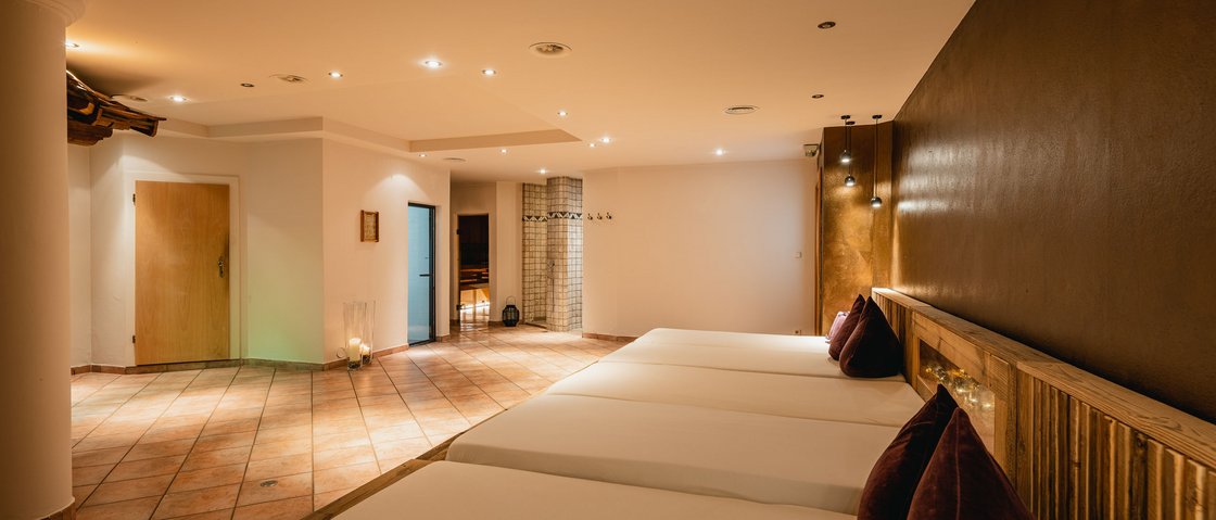 Ab ins Wellnesshotel in Neustift im Stubaital Ruhiger Wellnessraum mit Liegen, warmem Licht und modernem Design